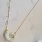 Close up of polymer clay necklace on a white background. Necklace is made of pearlescent clay.