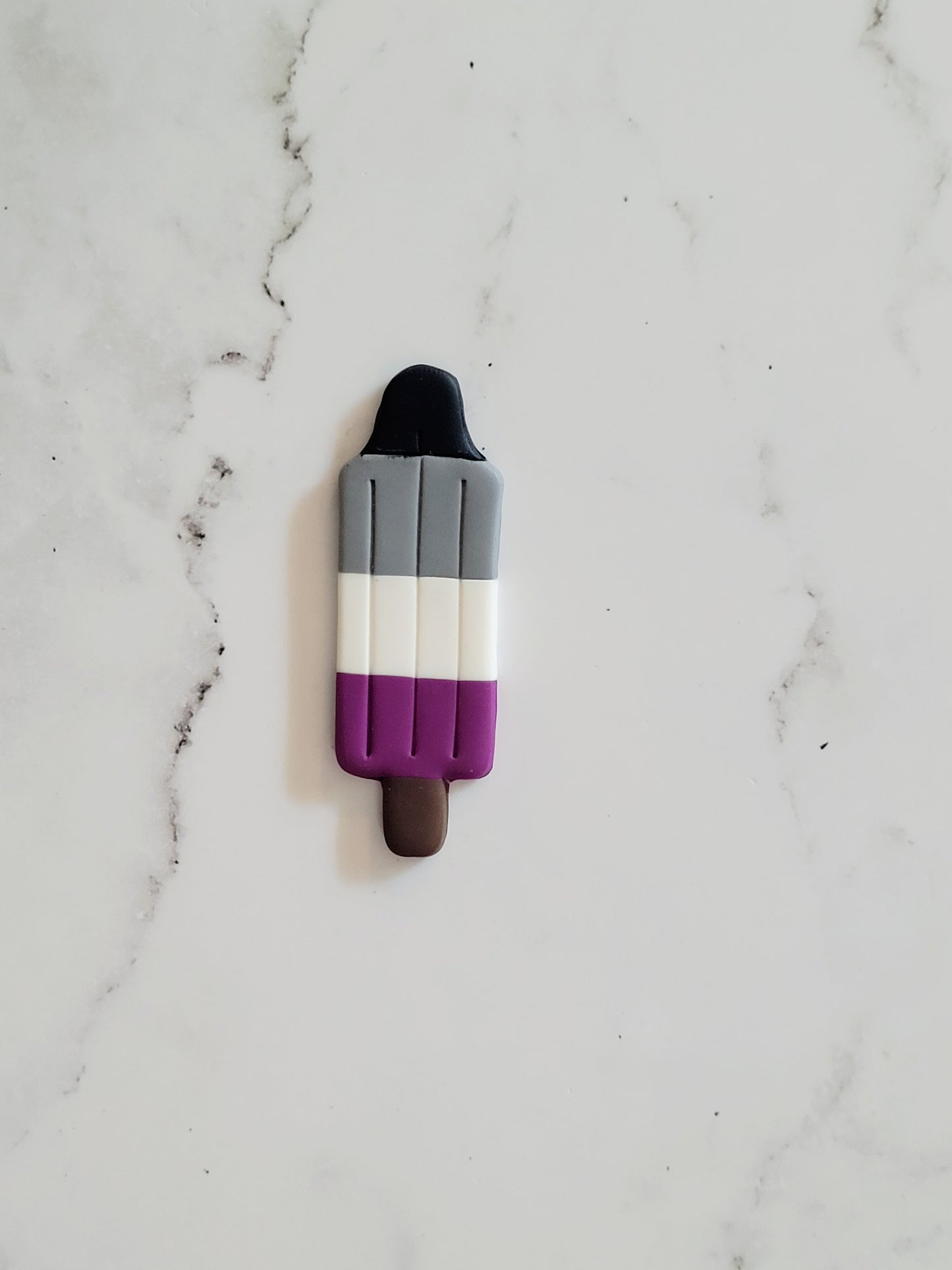 Closeup of the Asexual Pride Flag Bomb Pop Pin