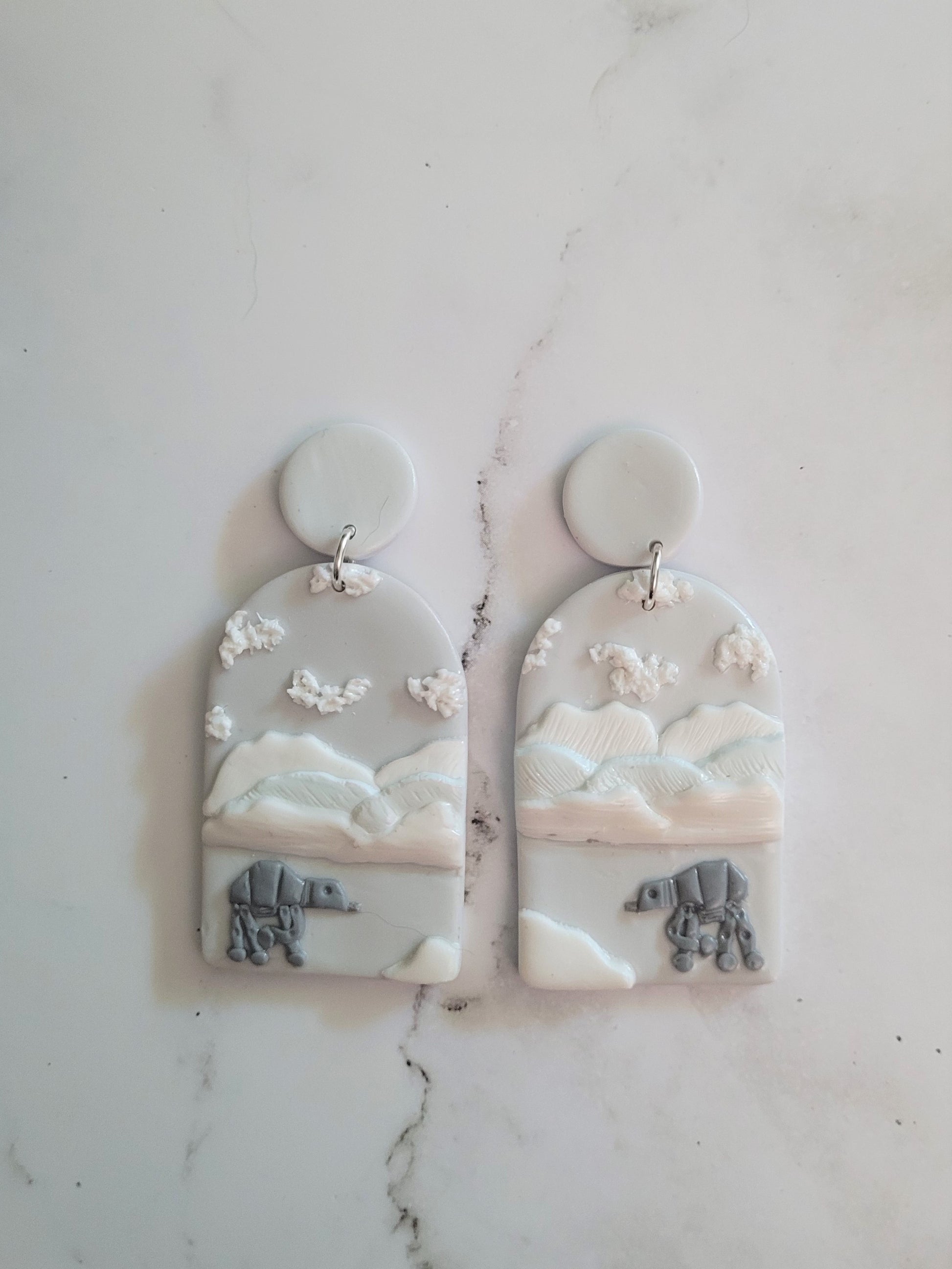 Closeup of Arch earrings with a icy landscape