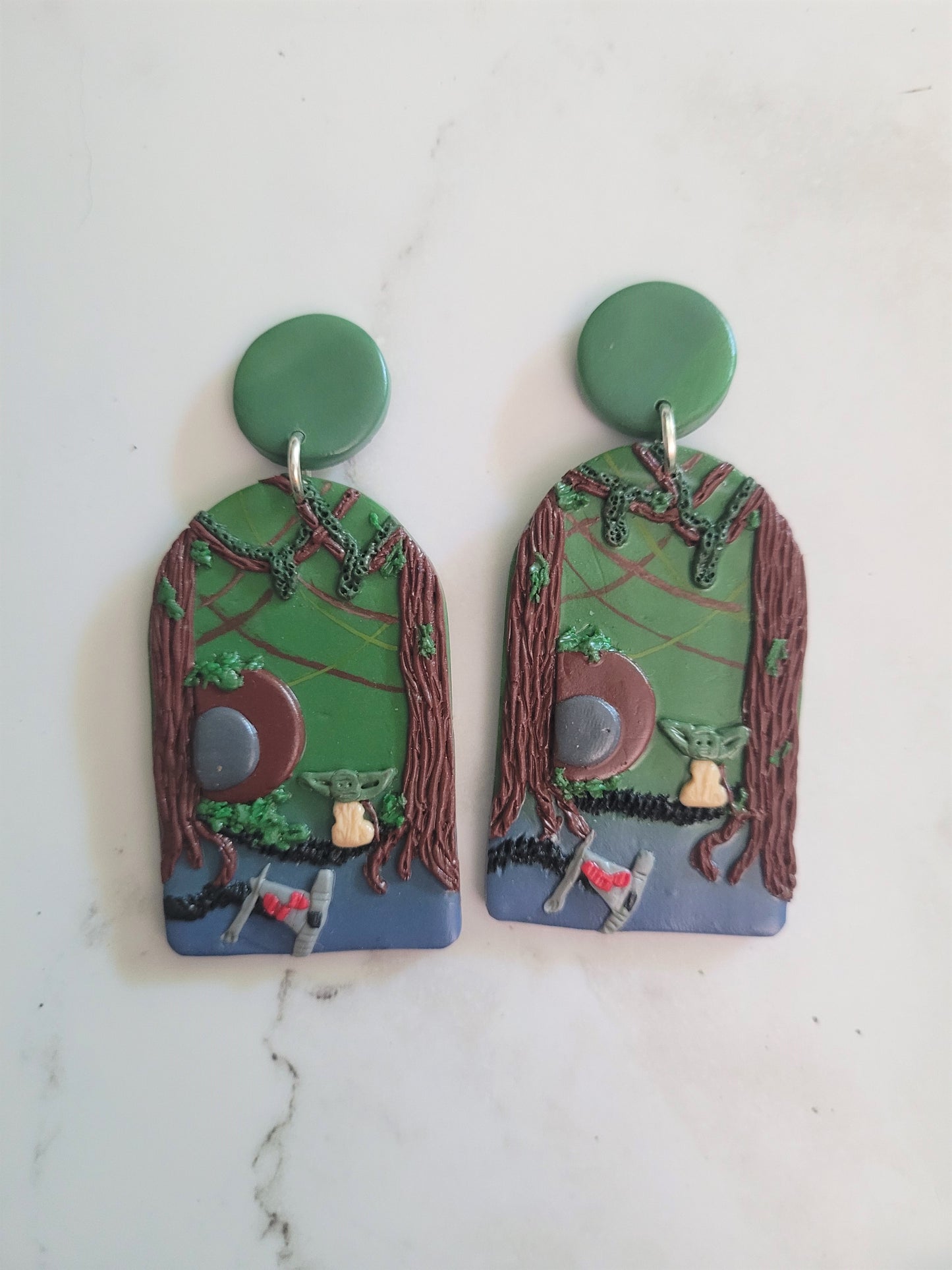 Closeup of Arch earrings with a swamp landscape