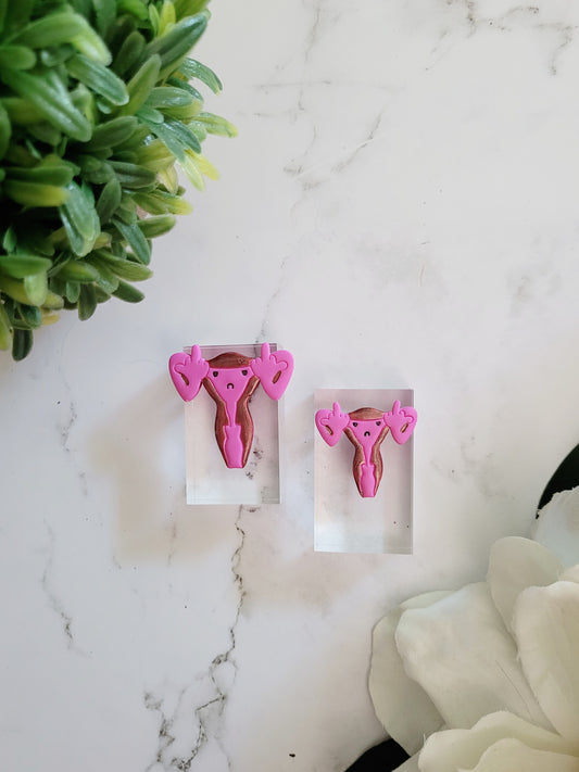 Pink uterus pin with middle finger fallopian tubes. 