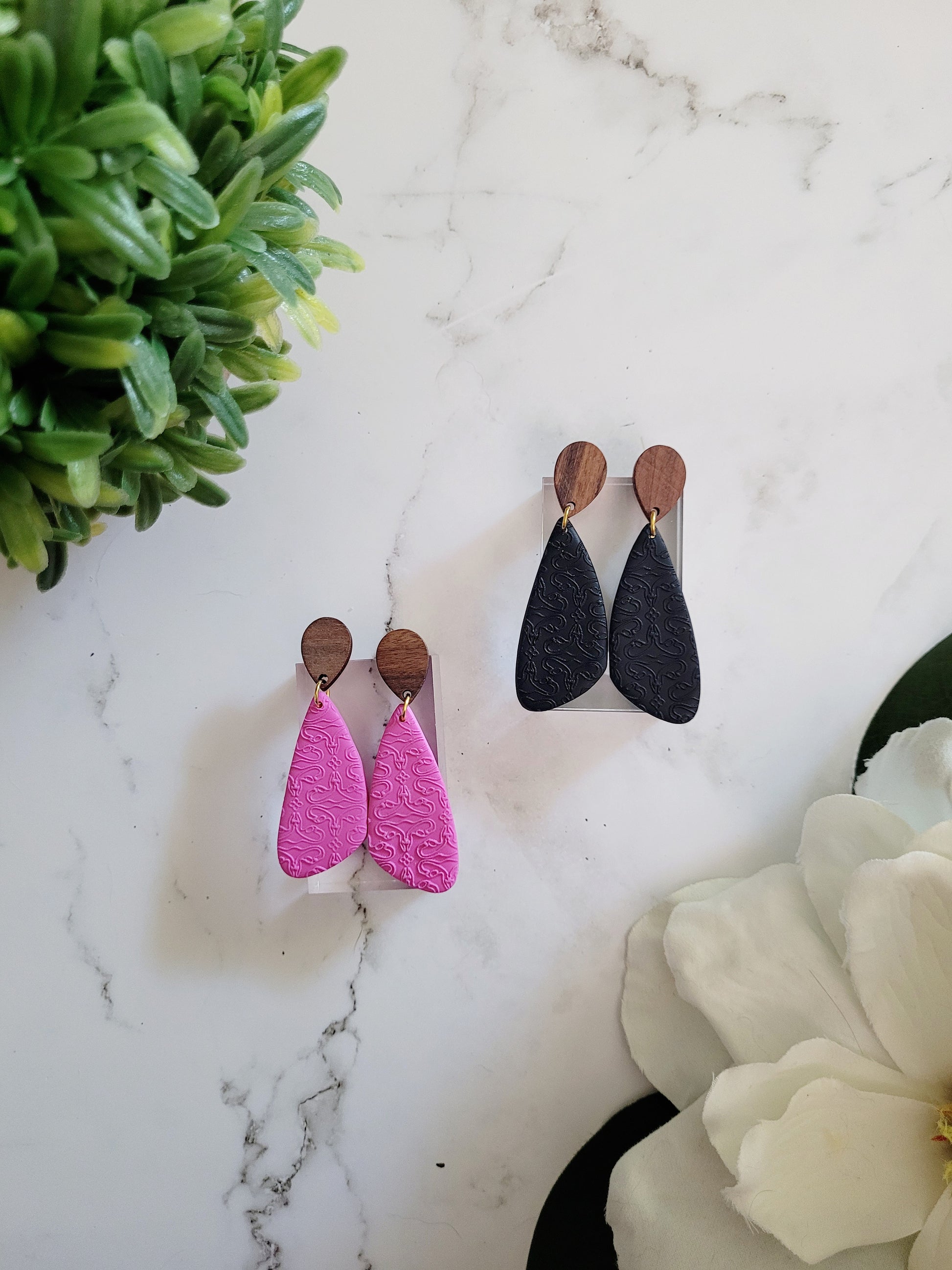 wood and clay earrings with uterus embossing.