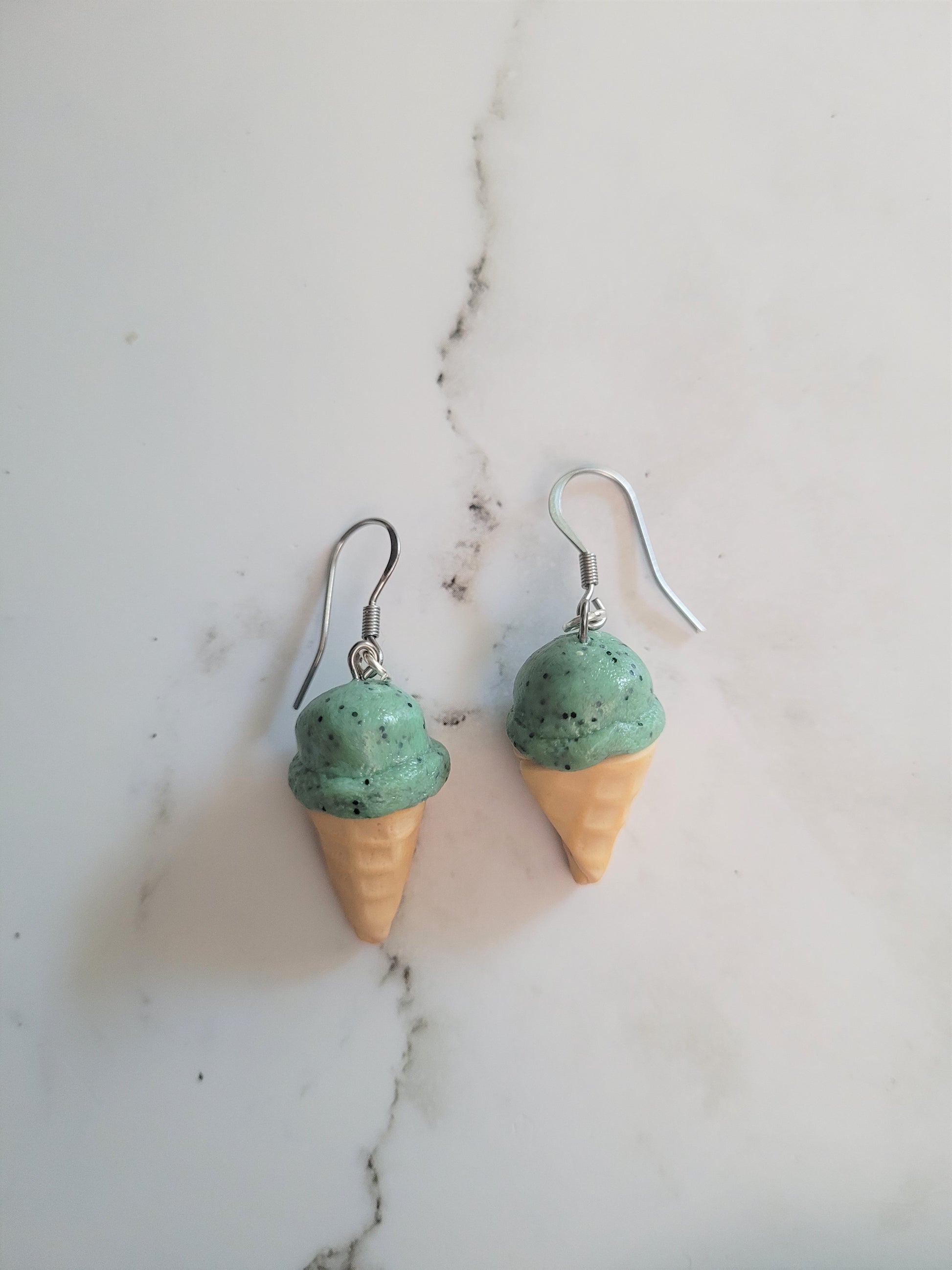closeup of 3d mint chip ice cream cone earrings. 