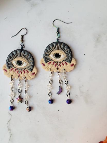 close up of All seeing eye earrings in light skin tones