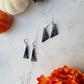 2 pairs of black glitter earrings with white spider webs