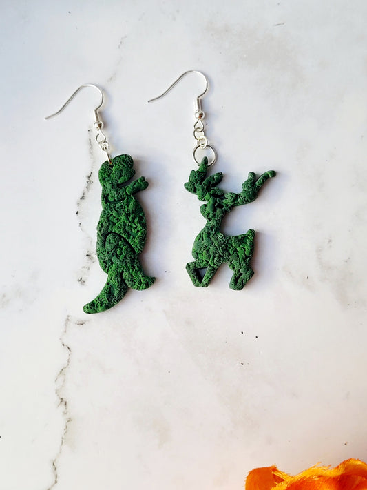close up of Edward Scissorhands themed topiary earrings on a marble background.