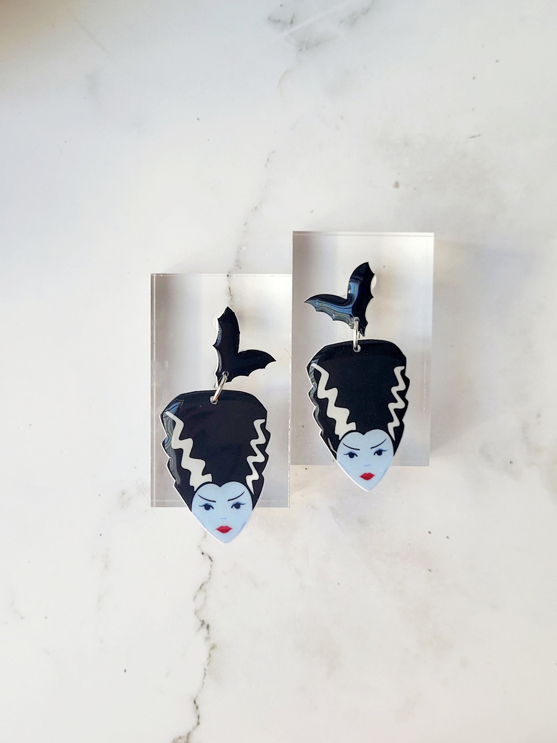 close up of Bride of Frankenstein earrings on a marble background. 