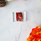 close up of stuffing box pins on a marble background with fall foliage. 