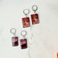 Close up of cranberry sauce and stuffing box earrings on a marble background with fall foliage.