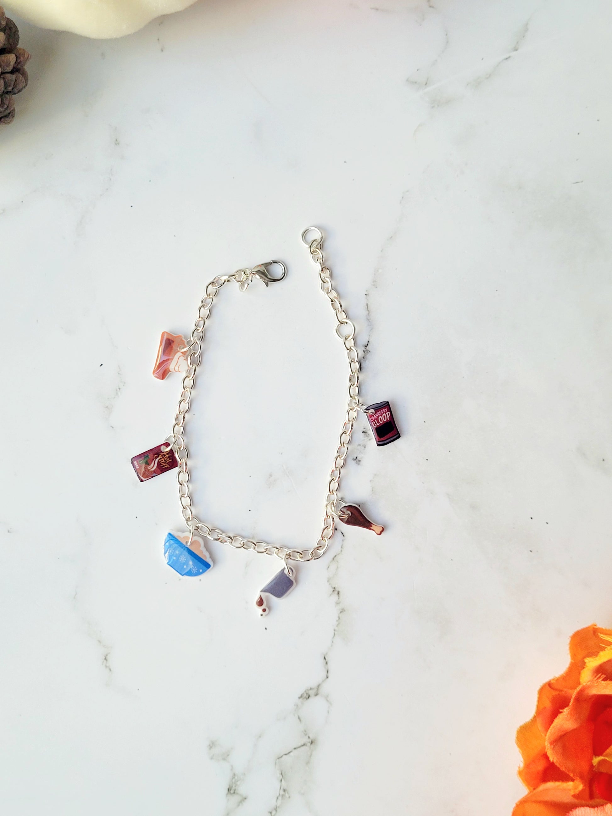 silver charm bracelet with thanksgiving themed charms on a marble background. 