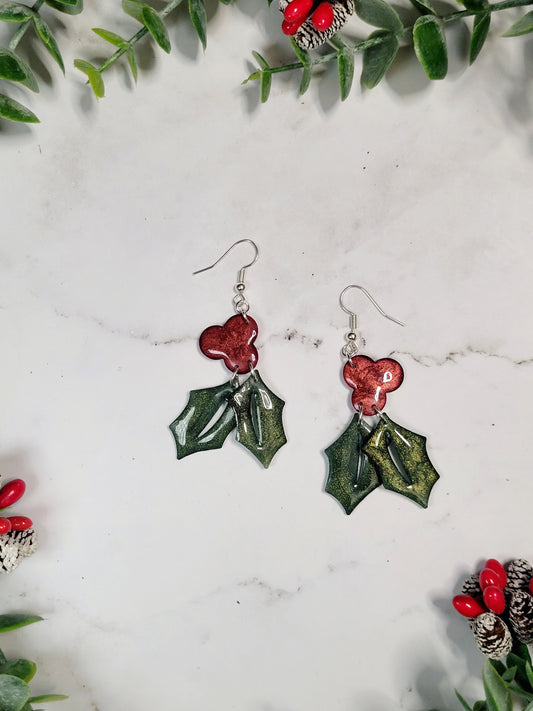 close up of Glitter holly sprig earrings on a marble background 