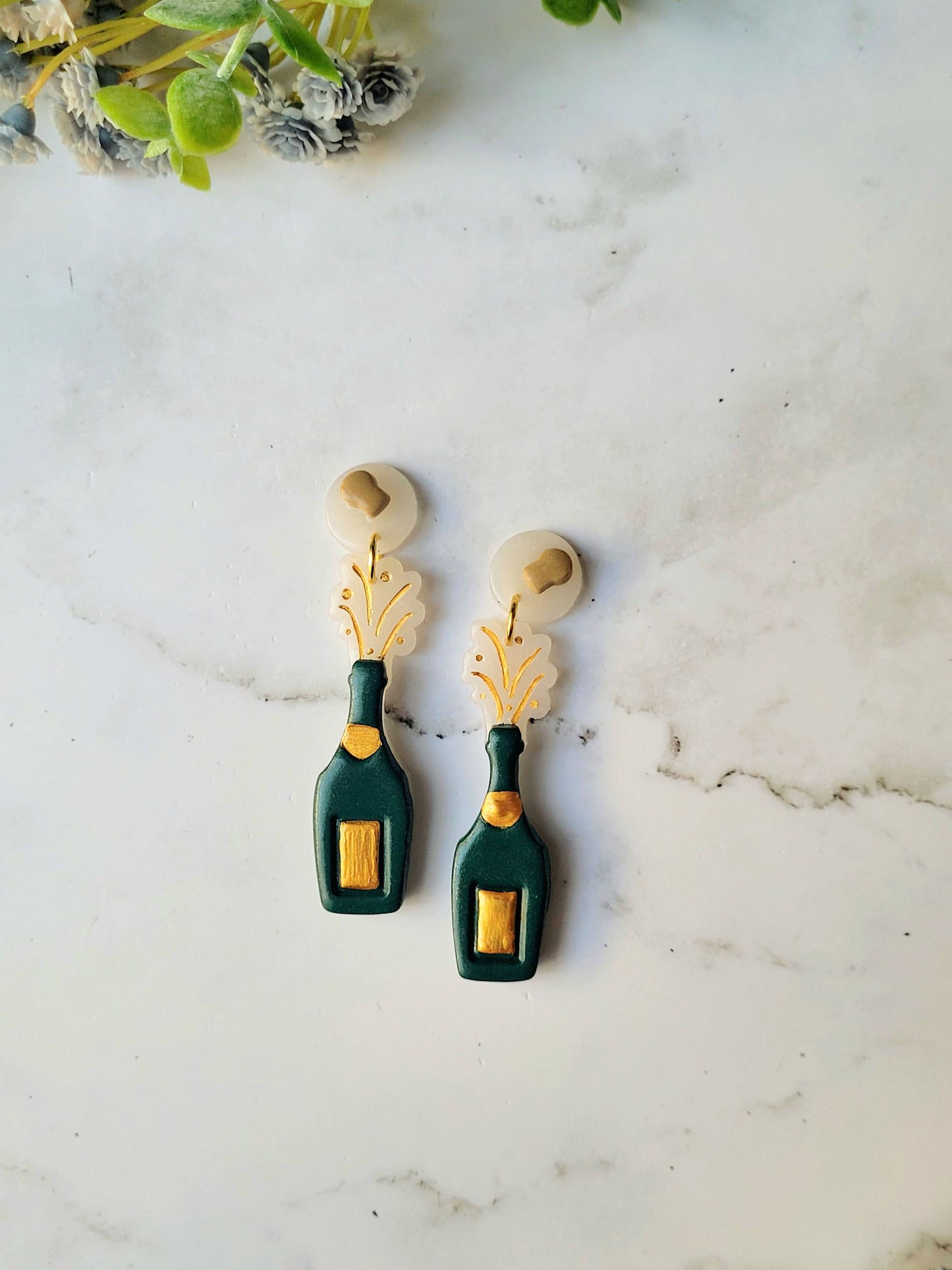 close up of the exploding champagne bottle with cork studs on a marble background.