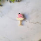 Pink Elephant in a champagne coupe brooch on a marble background .