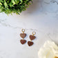 Chocolate and gold heart truffle earrings on a white background. 