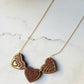 close up of Chocolate and gold heart truffle necklace on a white background.