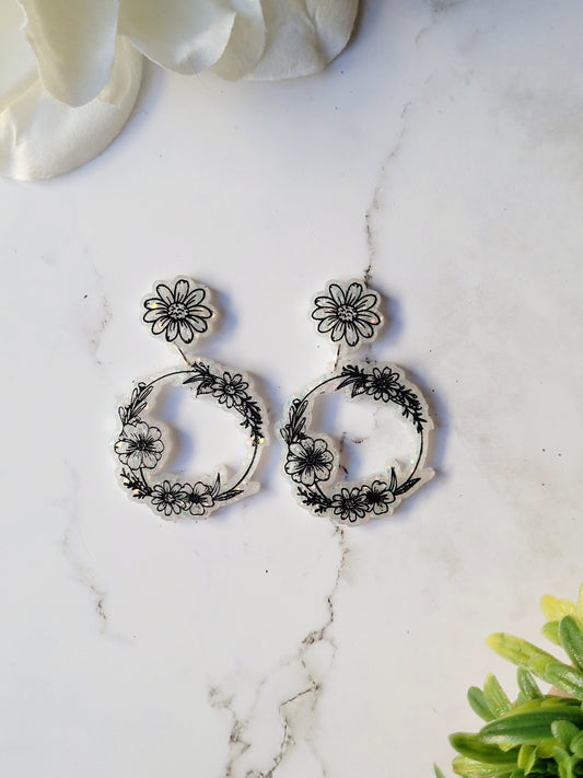 close up of Ditsy floral hoops in white on a marble background.