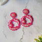 close up of Ditsy floral hoops in pink on a marble background.
