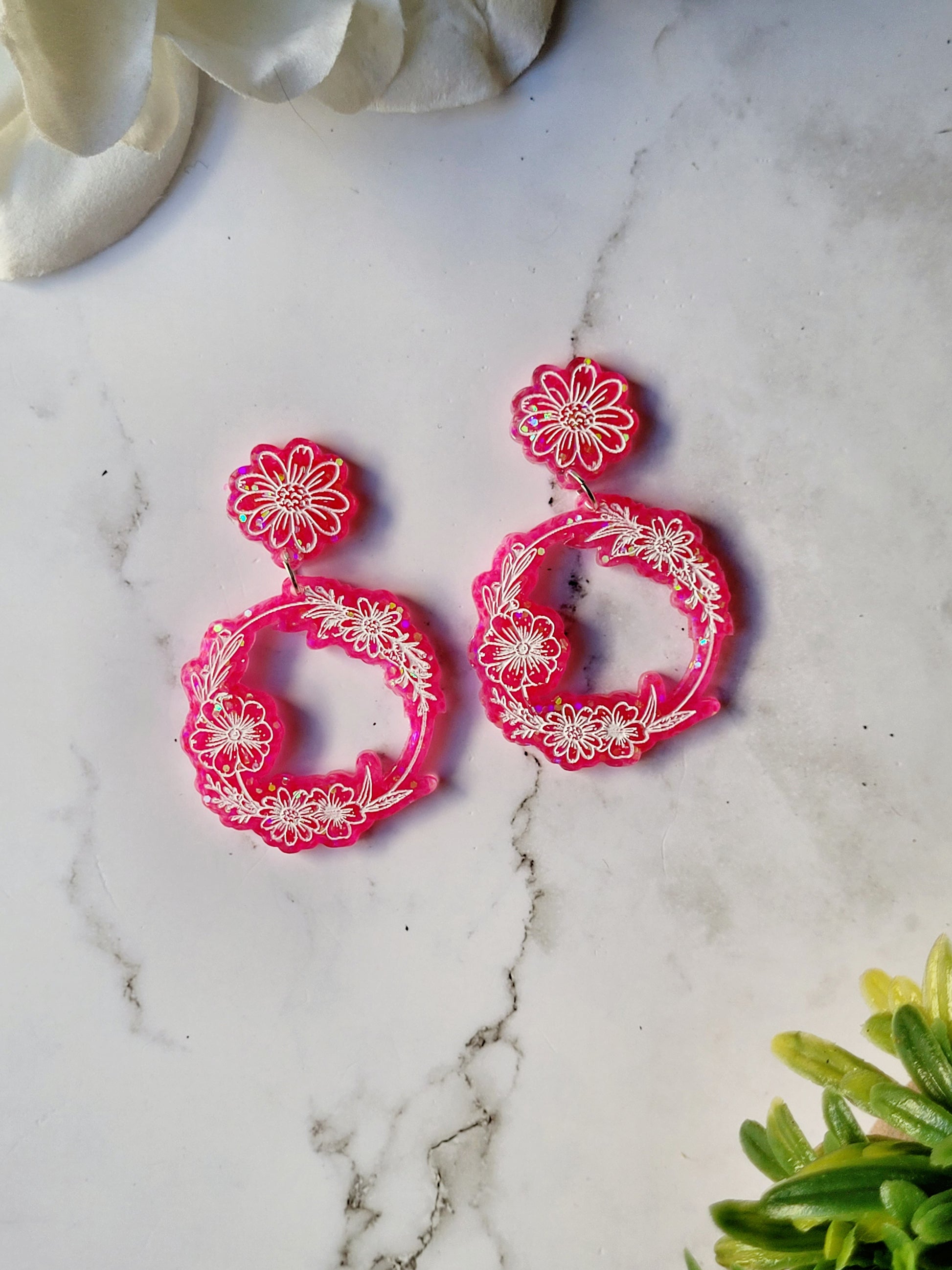 close up of Ditsy floral hoops in pink on a marble background.