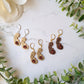 3 skin tones of pregnant women earrings on a marble background. 