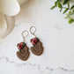 dark skin toned mother and child earring with flowers on a marble background