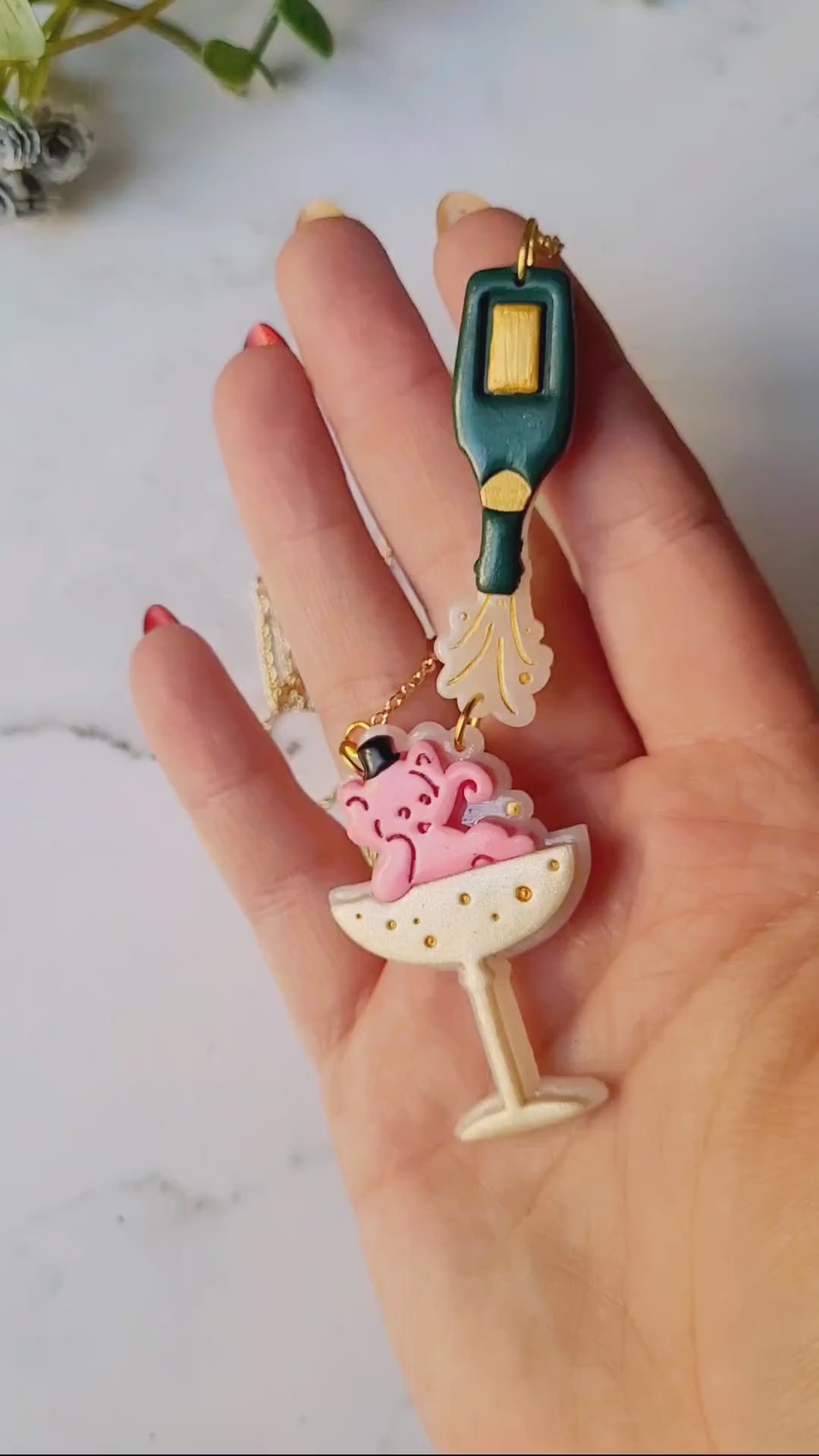 video close up of Pink Elephant in a champagne coupe with a champagne bottle necklace 