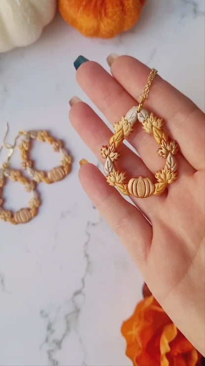 video close up of fall harvest themed teardrop necklace on a marble background