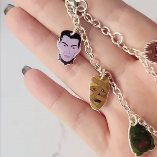 video close up of universal monster charm bracelet on a marble background .