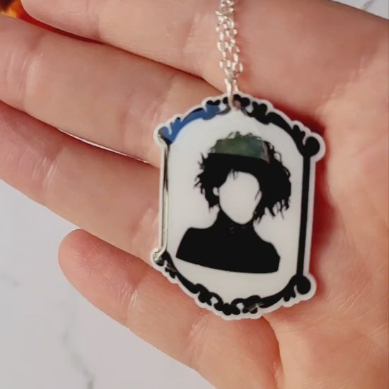 video close up of Edward Scissorhands themed pendant on a marble background.