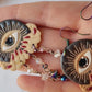 video close up of all seeing eye earrings in all three skin tones