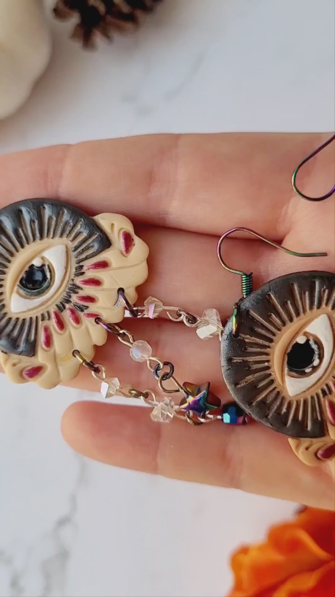 video close up of all seeing eye earrings in all three skin tones