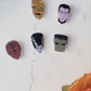 video closeup of 6 universal monster head lapel pins on a marble background