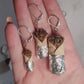 Closeup of the three burrito earring sizes to show details while sitting in palm of hand. 