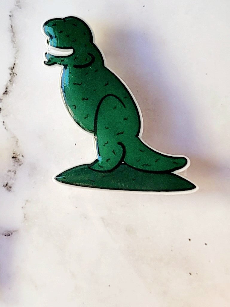 closeup of Edward Scissorhands themed dino brooches on a marble background.